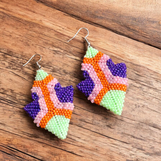 Handmade Abstract Bloom earring featuring integrated vibrant hues of lime green, purple, orange, and pale salmon pink on a wooden plate.