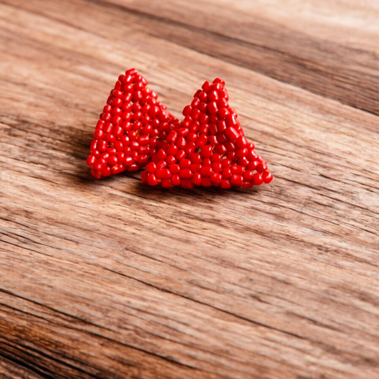 Handmade Pyramid Stud earring in scarlet red with a sleek triangular design on a wooden backdrop.