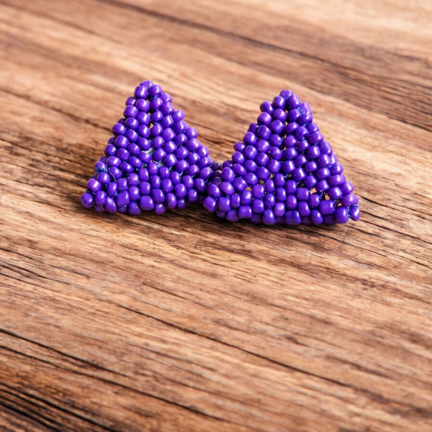 Handmade Pyramid Stud earring in violet purple with a sleek triangular design on a wooden backdrop.